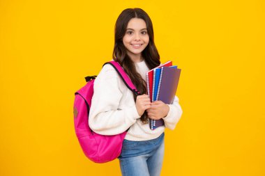 Öğrenci kız, sarı izole edilmiş stüdyo geçmişi hakkında kitap tutuyor. Okul ve eğitim kavramı. Okula dönelim. Mutlu yüz, pozitif ve gülümseyen genç kız duyguları