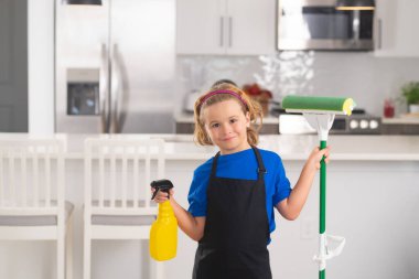 Çocuklar temizliğe yardım ediyor, evi temizliyor. Ev hizmetleri. Sevimli çocuk mutfağın içini temizlemeye yardım ediyor.