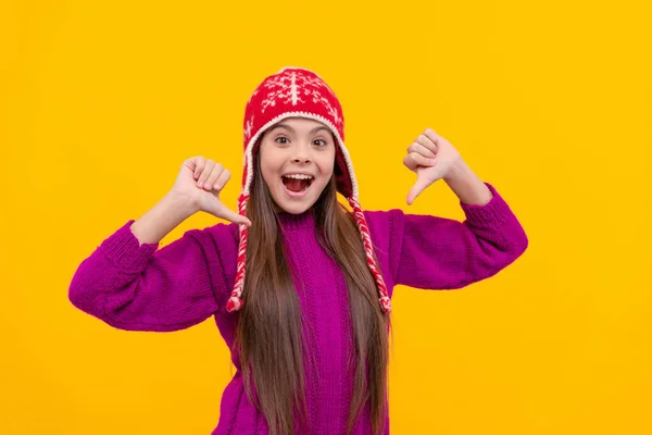 小孩穿着黄色背景的保暖衣服 孩子们冬天的时尚和美丽 穿针织物的少女 表达积极的情感 手指尖 戴耳瓣帽惊讶的孩子 — 图库照片