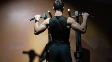 Sporcunun spor salonunda barfiks egzersizi yapması. Spor salonunda barfiks çeken sporcu. Sporcu spor salonunda spor barfiks ekipmanıyla antrenman yapıyor..