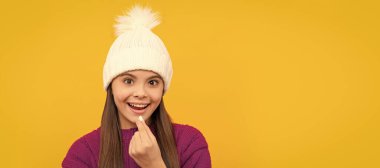 childhood health. child in winter hat taking pill. food supplement. Horizontal poster of isolated child face, banner header, copy space
