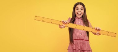 Şaşırmış genç kız cetvel tutuyor. Okula dönüyorum. Cebir ve geometri. Çocuk matematik okuyor. Öğrenci pankartı. Kopya alanı olan öğrenci portresi