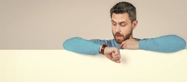 İnsan yüzü portresi, fotokopi alanı olan pankart. Şok adam boş beyaz afiş arkasında reklam ve alışveriş saati için fotokopi alanı ile zamanı kontrol ediyor.