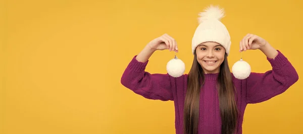 冬の女の子 冬の帽子の幸せな子供 装飾ボールを持つ子供 10代の女の子は黄色い背景に雪玉を持ってる クリスマスの子供の女の子のバナー スタジオの子供の冬の肖像画とともにコピースペース — ストック写真