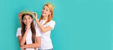 Anne ve kız çocuk afişi, kopyalama alanı, izole edilmiş arka plan. Güzellik kraliçesi tacını takan mutlu yarışmacı kız çocuk mavi arka plan, prenses