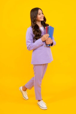 Okula dönelim. Kitabı öğrenmeye hazır ergen bir kız öğrenci. İzole edilmiş sarı stüdyo geçmişi olan liseli kızlar.