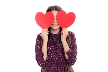 Neşeli romantik genç kız beyaz arka planda izole edilmiş sevgililer günü için aşkın kırmızı kalp sembolünü tutuyor. Mutlu gülümseyen genç kızın portresi.