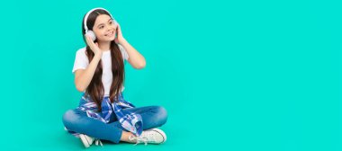 happy teen girl listen to music in wireless headphones. Child portrait with headphones, horizontal poster. Girl listening to music, banner with copy space