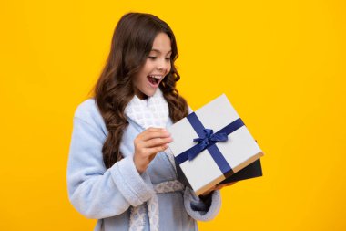 Şaşırmış genç kız. İzole edilmiş arka planda hediye kutusu olan çocuk. Doğum günü hediyeleri, sevgililer günü, yeni yıl ya da Noel. Heyecanlı bir ifade, neşeli ve mutlu.