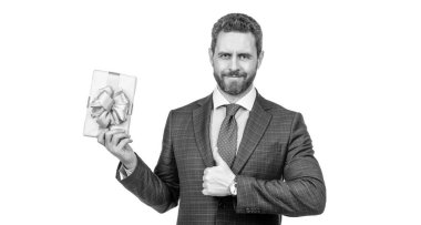 Takım elbiseli gülümseyen bir işadamı hediye kutusunu tutar. Parmağını beyazın üstünde tek başına gösterir. En iyi hediye..