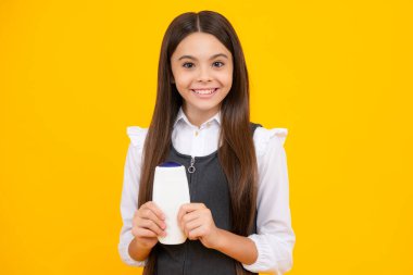 Teenage girl with shampoos conditioners or shower gel. Kids hair care cosmetic product, shampoo bottle