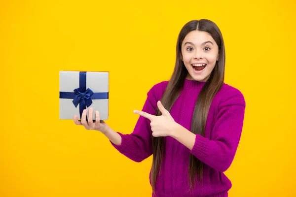 Excited face. Teenager child with gift box. Present for holidays. Happy birthday, Valentines day, New Year or Christmas. Kid hold present box. Amazed expression, cheerful and glad