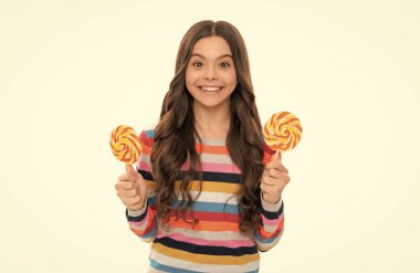 yummy. happy girl hold lollipop isolated on white. lollipop child. kid in colorful sweater hold lollypop. sugar candy on stick. caramel candy shop. childhood happiness. teen dental care. sweet tooth.
