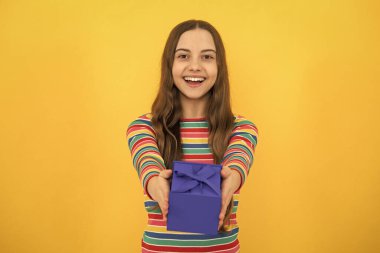 12, 13, 14 yaşlarında elinde Noel hediyesi olan genç bir kızın portresi. Gençler doğum günü hediyesi veriyor.