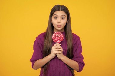 Teenage girl with lollipop, child eating sugar lollipops, kids sweets candy shop. Excited teenager girl. Surprised emotions of young teenager girl