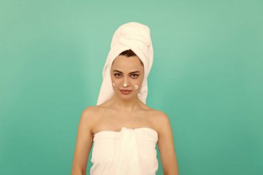 Genç bayan mavi arka plana krem sürüyor..