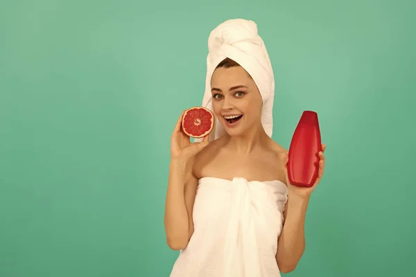 Verrast Dame Handdoek Met Grapefruit Shampoo Fles Blauwe Achtergrond — Stockfoto