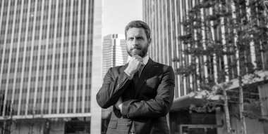 serious charismatic mature businessman in suit outside the office, business fashion.