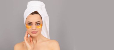 Göz bandı. Terry Havlu 'lu şehvetli kadın cilt ve kaplıca için altın göz bandı kullanıyor. Güzel kadın, izole edilmiş yüz portresi, taklit alanı olan pankart.