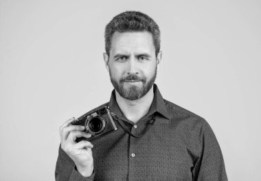 Günlük stilde sakallı adam. Fotoğraf makinesi, gri arka plan, kameraman..