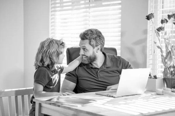 bearded dad or school private tutor teaching boy son with modern laptop, family.