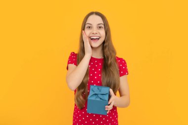 Stüdyonun arka planında izole edilmiş hediye kutusunu tutan genç kız. Hediye, selam ve hediye konsepti. Doğum günü tatili kavramı