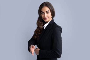 Kadın ofis çalışanı, başarılı menajer. Takım elbiseli bir iş kadını gülümseyerek selamlama ve hoş geldin demek için tokalaşıyor. Başarılı bir iş. İş kadını tokalaşıyor