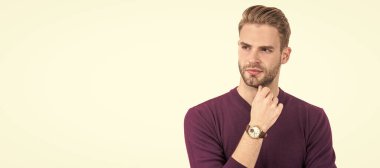 Tıraşsız sakallı yakışıklı adam beyaz tenli, ciddi, sıradan tarzda düşünceli görünüyor. İnsan yüzü portresi, kopyalama alanı olan pankart