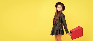 cheerful stylish teen child shopping. kid in hat hold shopping bag. autumn season trends. Banner of shopping child girl, studio poster header with copy space