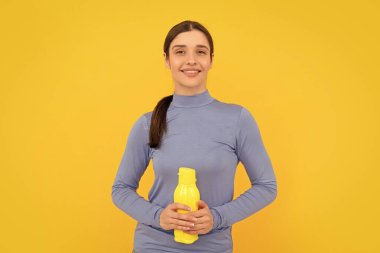 Spor şişesi su ve susuzlukla dolu mutlu genç bir kız..