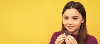 Pleasure of eating chocolate alone. Happy child eat chocolate. Eat it because you deserve it. Horizontal poster of isolated child face, banner header, copy space