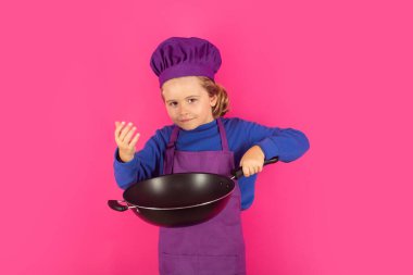 Çocuk tencereyle yemek pişiriyor. Şef çocuk sağlıklı yemek hazırlıyor. Şef şapkalı çocuk portresi