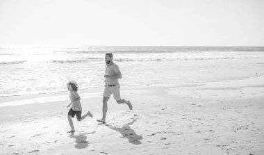 Baba ve çocuk ailesi yaz plajında koşuyor, kopyalama alanı, aile tatili.