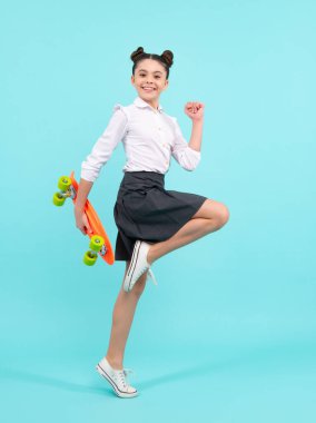 Modayı takip eden genç modelin gündelik görüntüsü. Genç yeniyetme hippi şehir hayatı. Sokak tarzı hippi elbiseli, kaykaylı bir kız çocuğu.