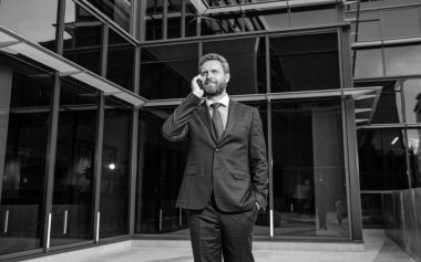 İş adamı açık havada akıllı telefonda konuşur. Patron adam konuşuyor. İş görüşmesi. Ses bağlantısı. Yetişkin CEO cep telefonundan konuşuyor. Telefon var. mobil bağlantı teknolojisi. iletişim.