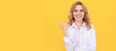 Beyaz gömlekli mutlu sarışın iş kadını fotokopi alanını işaret ediyor, reklam. İzole edilmiş yüz portresi, taklit alanı olan pankart