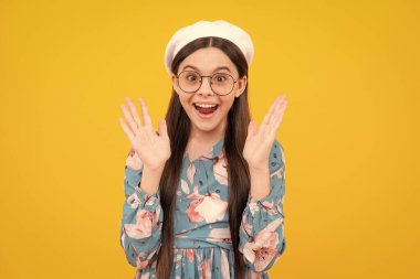 Heyecanlı genç, şaşkın ve neşeli duygular. Yüzünde şok ifadesi olan genç bir kız çocuğu. Şaşırmış yüz ifadesi, sarı arka planda izole edilmiş. Mutlu sürpriz.