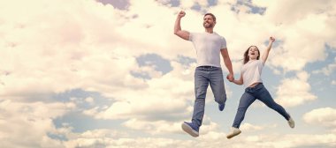 Baba ve kızı gökyüzüne sıçrıyor, fotokopi alanı olan bir pankart. Mutlu baba ve kız gökyüzüne atlıyor. mutluluk.