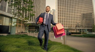 be my valentine. boxing day. handsome man with present box. entrepreneur carry birthday gift. guy hold shopping bags. mens day. glad businessman with packages. sale and discount. surprise for him.