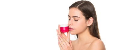 Kadın yüzü, yakın portre, kopyalanmış afiş. Genç kadın cilt için krem kavanozu tutuyor. Beyaz arka planda, fotokopi alanı ile izole edilmiş.