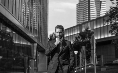 Yönetici ofis dışında. Erkek resmi moda. Kendine güvenen sakallı patron. Yetişkin bir iş adamı. İş başarısı. Takım elbiseli başarılı bir adam..