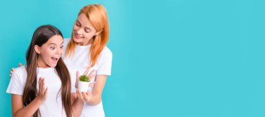 Anne ve kız çocuk afişi, kopyalama alanı, izole edilmiş arka plan. Sevgi ve şefkat. Şaşkın çocuk annesinin elinde tuttuğu saksıya bak. Evlatlık ve yetiştirme