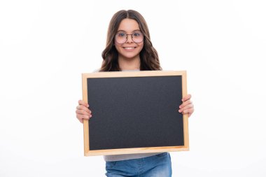 Okulun boş tahtasını tutan liseli genç kız beyaz arka planda izole edilmiş. Genç bir kız öğrencinin portresi. Mutlu kız yüzü, pozitif ve gülümseyen duygular