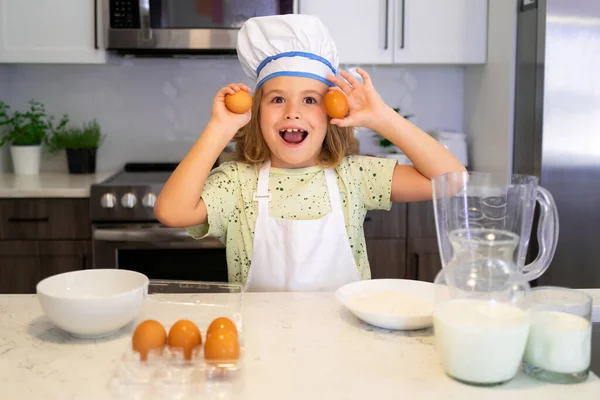 Child chef cook. Funny child stand at kitchen table have fun baking, doing bakery preparing food at home kithen. Healthy food. Little chef preparing healthy meal