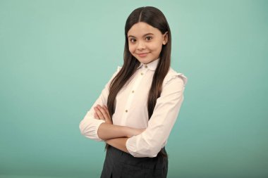 Genç kız sarı arka planda izole bir şekilde kollarını kavuşturmuş. Kopya alanı oluşturulmuş çocuk portresi