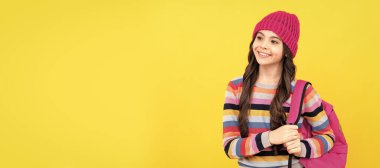 Sırt çantalı mutlu hippi kız okula gidiyor, okula geri dönüyor. Liseli kız öğrenci pankartı. Kopya alanı olan öğrenci portresi