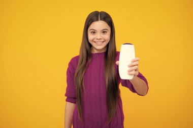 Child with shampoo conditioner. Daily cosmetic care. Teenager hold bottle of hair and skin care. Beauty health and cosmetics