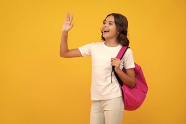 School girl in school uniform with school bag. Schoolchild teenager hold backpack on yellow isolated background