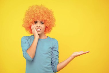 Kıvırcık saçlı komik çocuk. Eğlenme zamanı. Turuncu saçlı genç kız, palyaço. Kızgın yüz, üzgün genç kız duyguları.