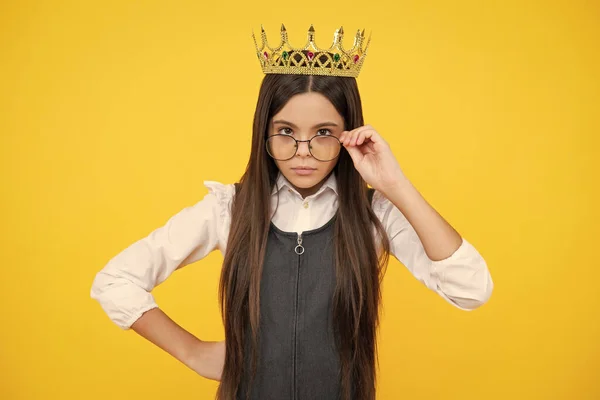 Teen child in queen crown isolated on yellow background. Princess girl in tiara. Teenage girl wear diadem. Serious teenager girl